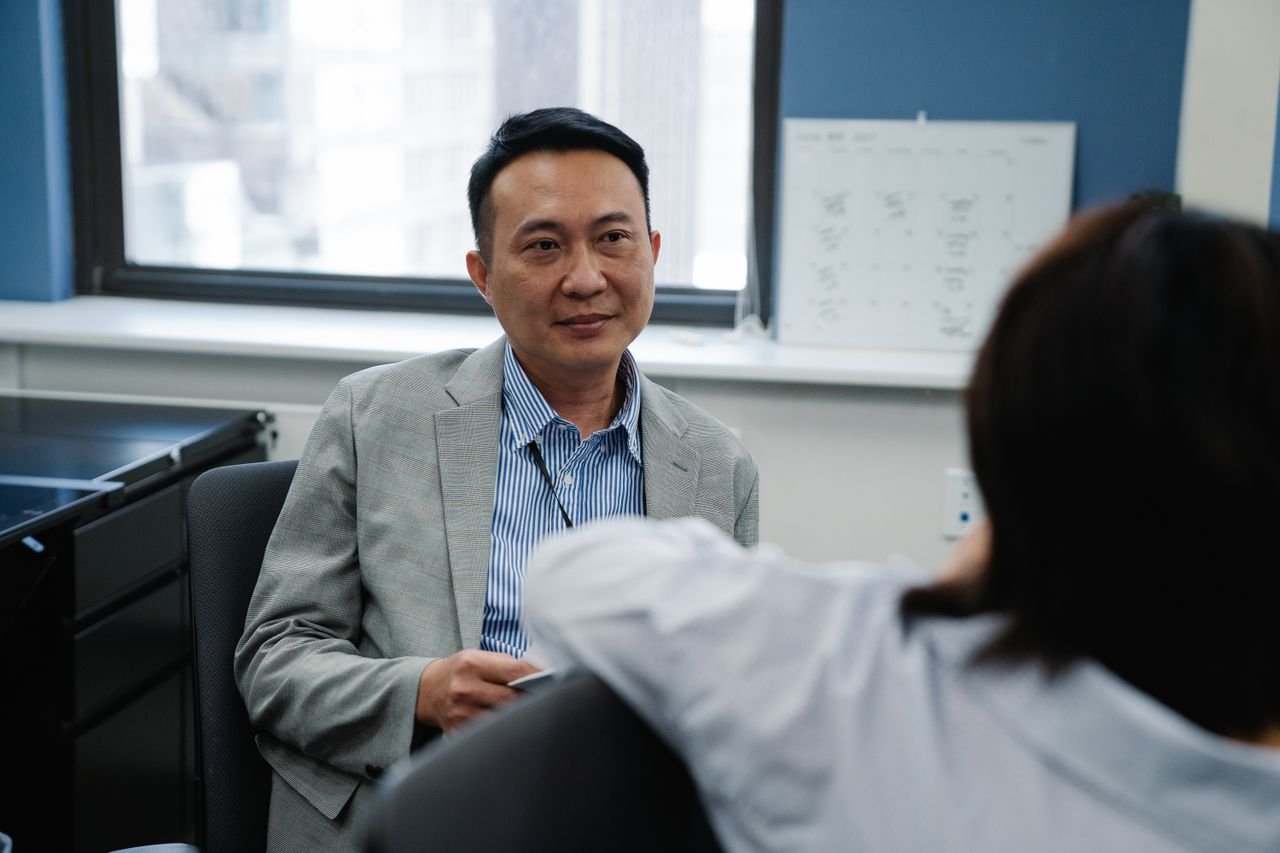 Two adults engaged in a professional discussion in a modern office setting, showcasing teamwork.